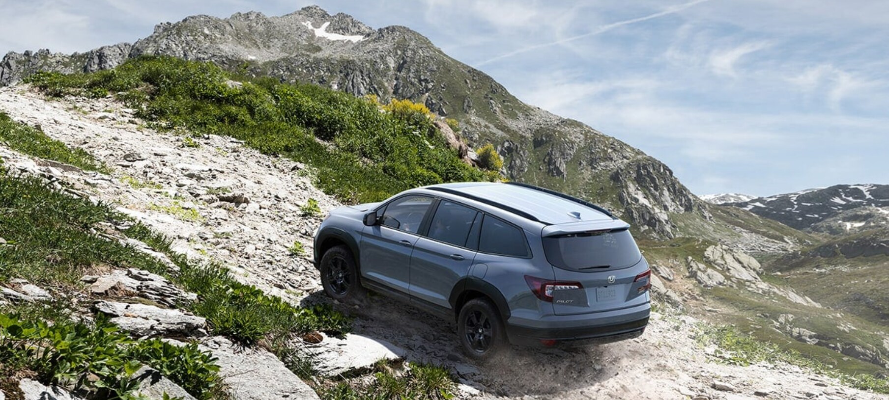 2022-Honda-Pilot-2.PNG A light blue 2022 Honda Pilot drives up a steep and rocky incline