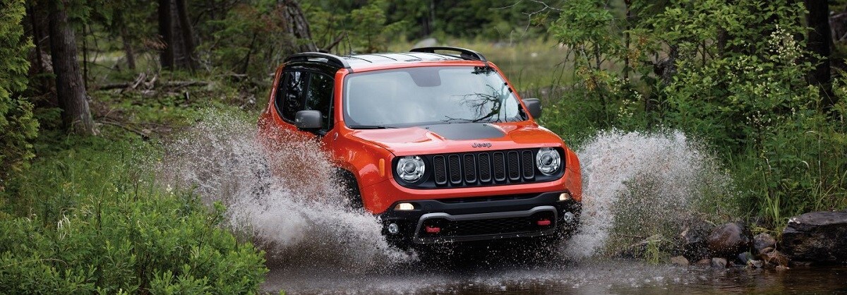 Orange Jeep Renegade driving through water