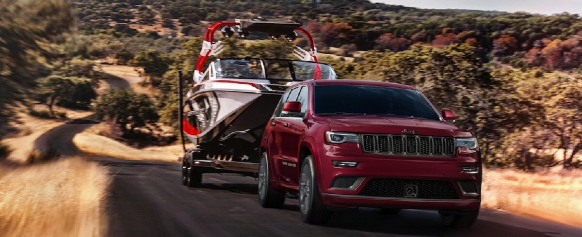 Red Jeep Grand Cherokee towing boat