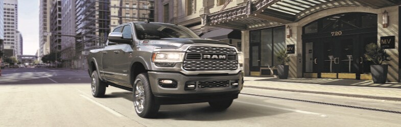 Dark Grey RAM 2500 front passenger side view driving through streets