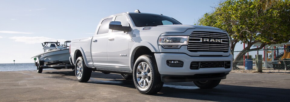 White RAM 2500 front passenger side view towing boat