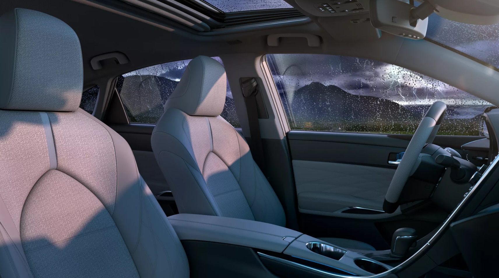 2022-Toyota-Avalon-Hybrid-4.PNG A view of the interior of a 2022 Toyota Avalon Hybrid with gray cloth upholstery during a rainstorm