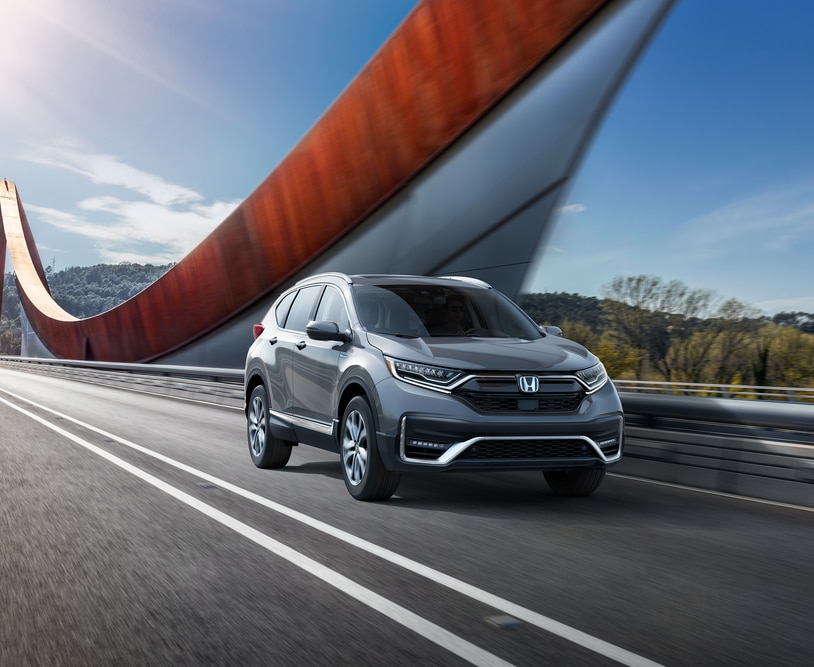 2022-Honda-CRVHybrid-Touring-SUV.png silver Honda CR-V Hybrid SUV driving over a bridge