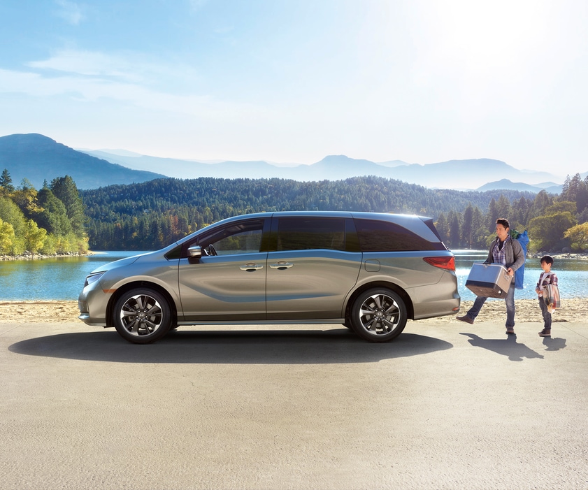 2022-Honda-Odyssey-Elite-Van.png silver Honda Odyssey, profile with driver using foot activated rear hatch