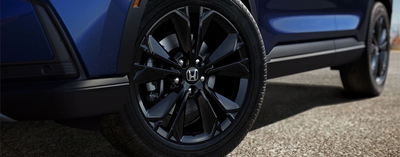 Honda%20CR-V%20for%20Sale%20-%202024%20Honda%20CR-V%20Sport%20Touring%20-%20Blue%20Wheel.jpg A close up of the wheel on a blue 2024 Honda CR-V Sport Touring Hybrid.