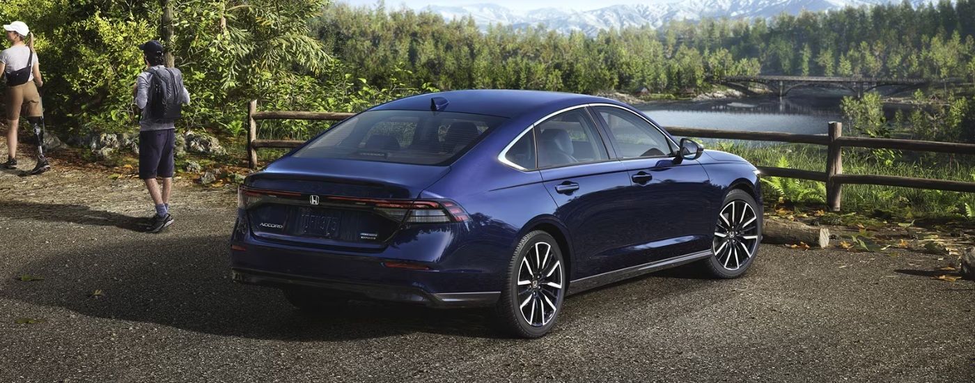 2026 blue Honda Accord rear view parked in front of a river.