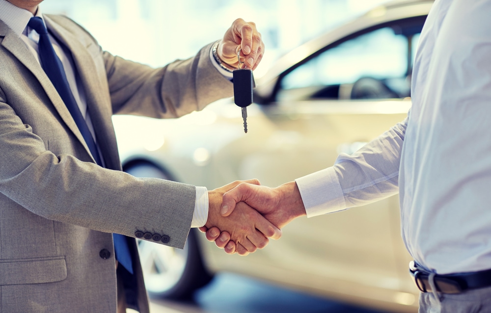 Salesman handing Keys to New Car Buyer.jpg
