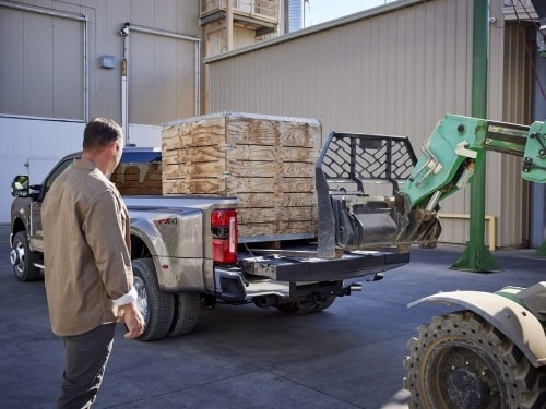 View of a tractor loading pallets in the bed of a 2025 Super Duty