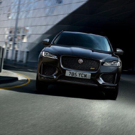 2020 JAGUAR F-PACE DRIVING DOWNTOWN IN A CITY. IMAGE SHOWS BLACK F-PACE.