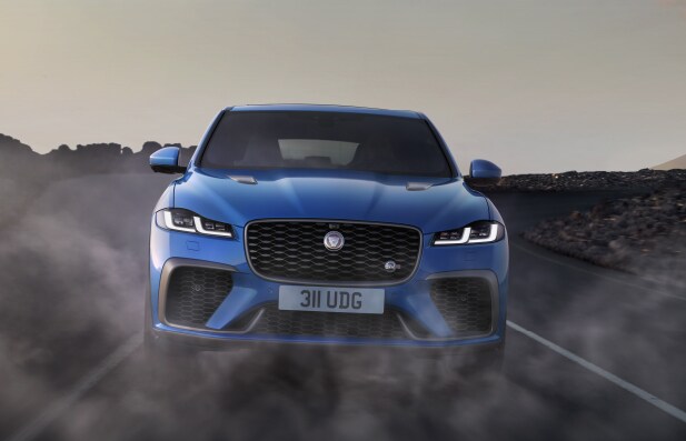 BLUE JAGUAR F-PACE DRIVING THROUHG DESERT.