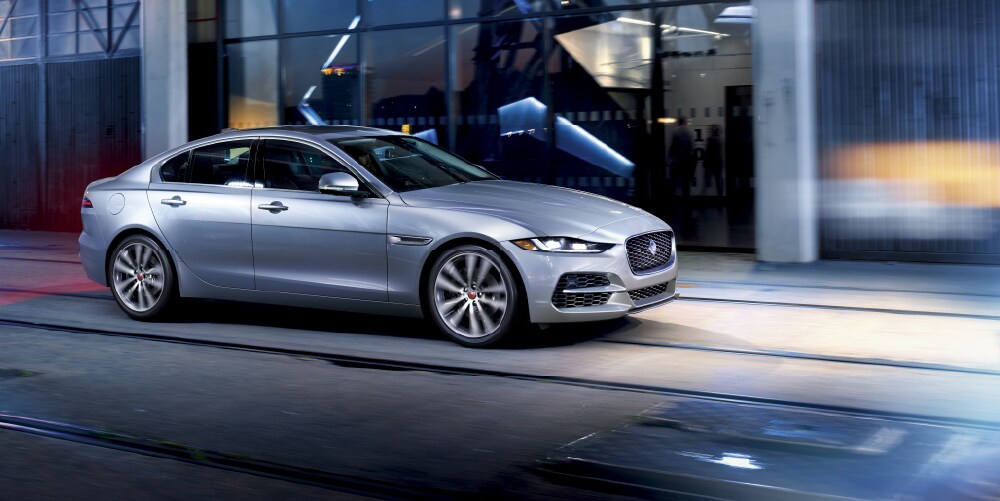 SILVER 2020 jaguar xe driving down road in City.