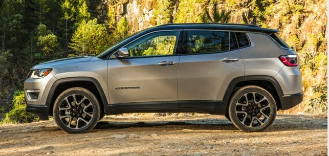 2019 Jeep Compass SUV Sport facing left near pines and rocks_2.PNG