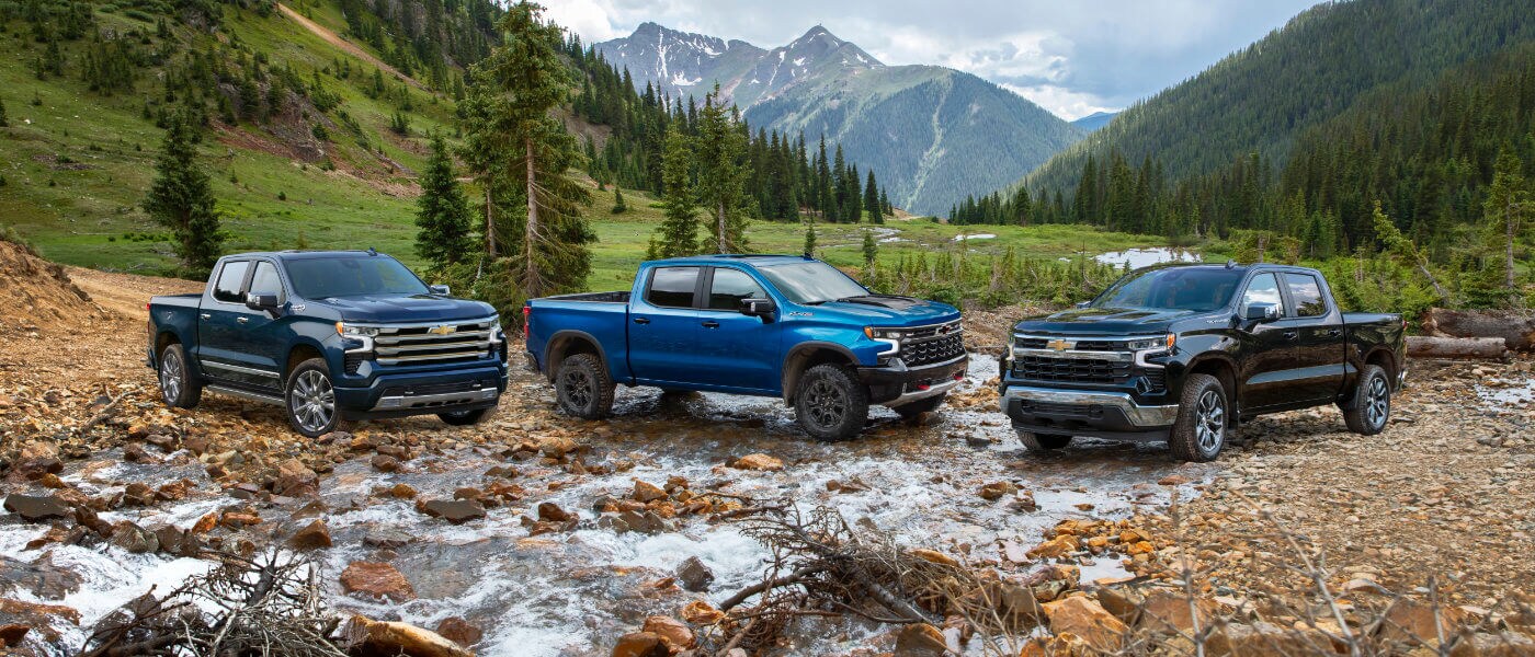Three Chevy Silverados parked in the mountains