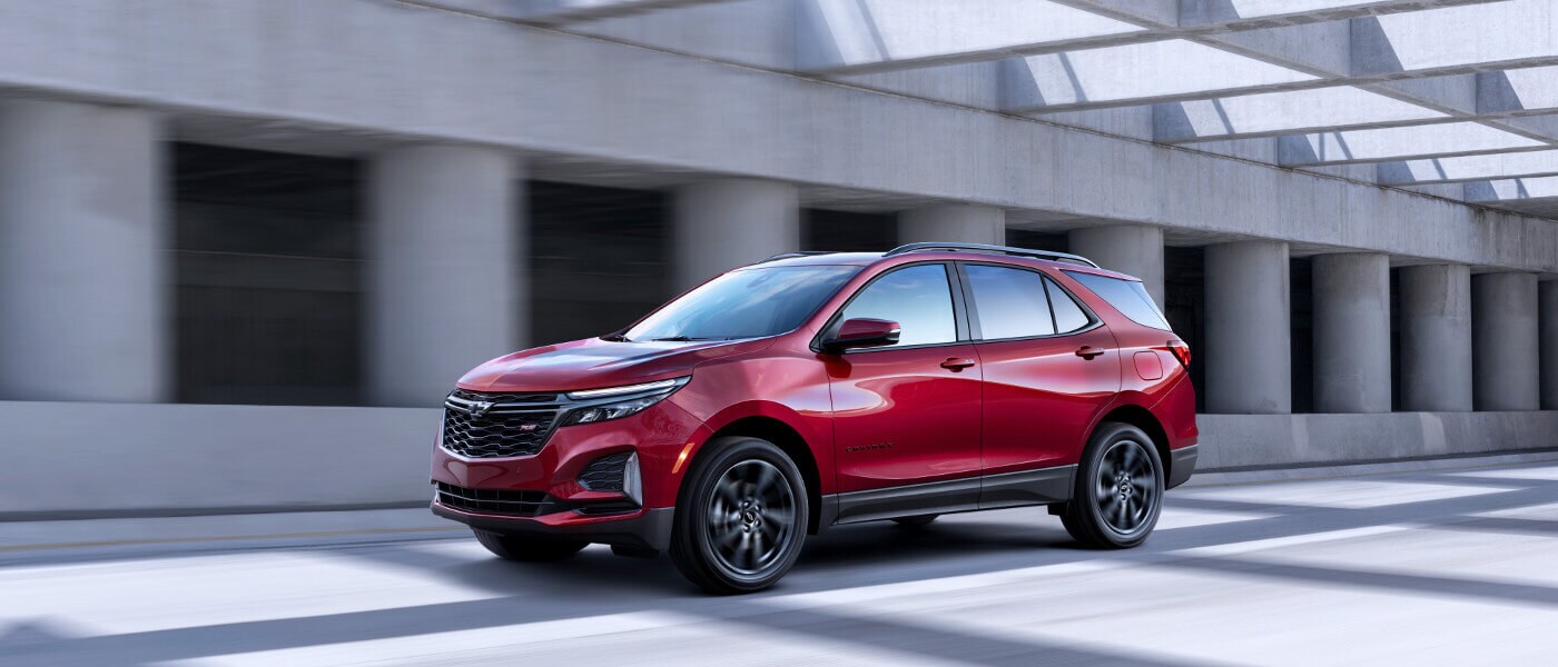 2022 Chevy Equinox driving in front of a concrete structure