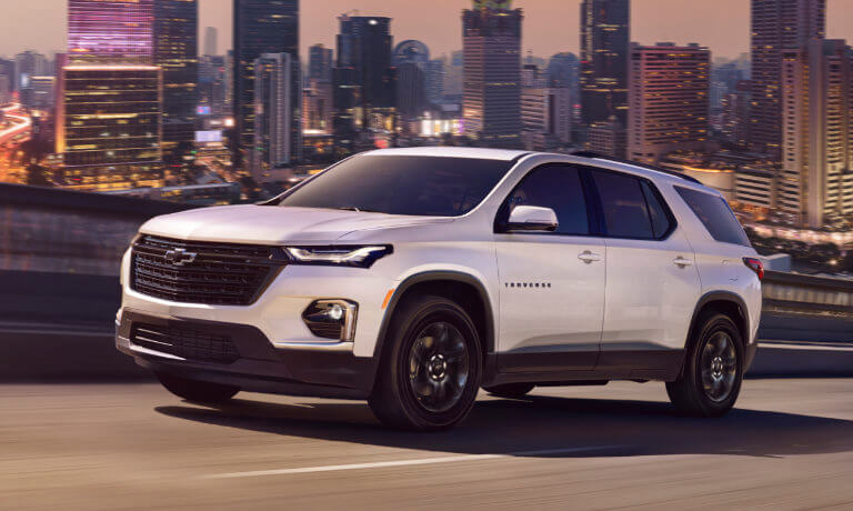 2023 Chevy Traverse driving by city skyline