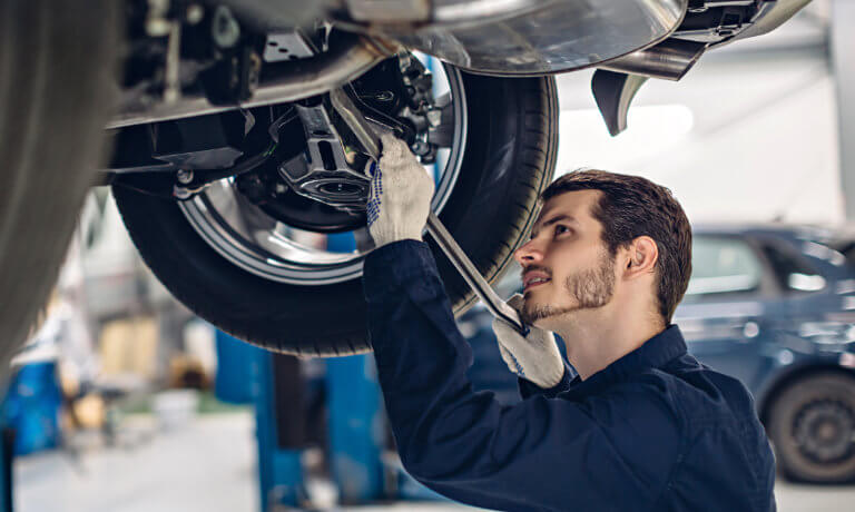 Service technician working under vehicle