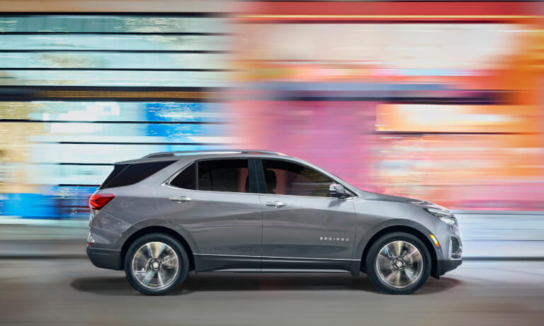 2024 Chevy Equinox speeding past a colorful wall