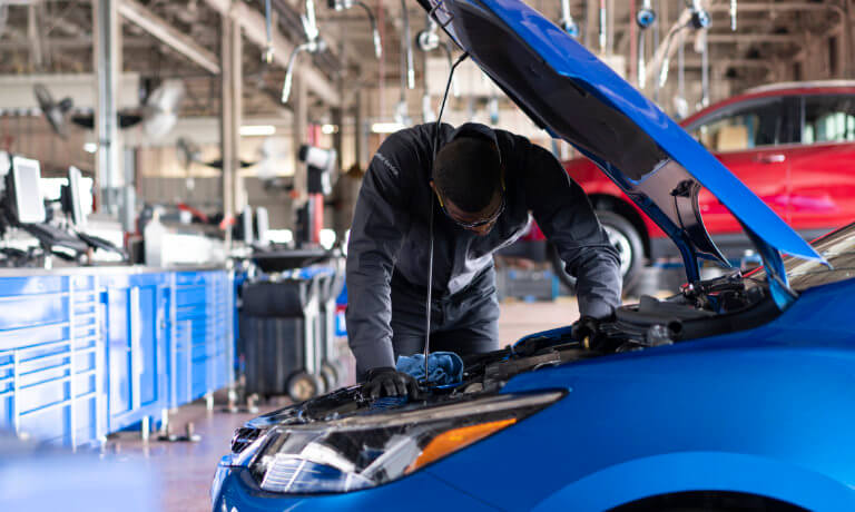 Service technician working under vehicle hood