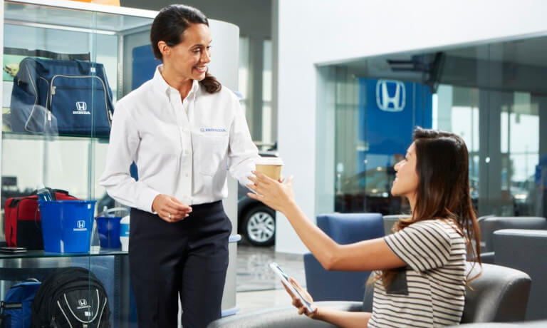 Employee handing coffee to customer