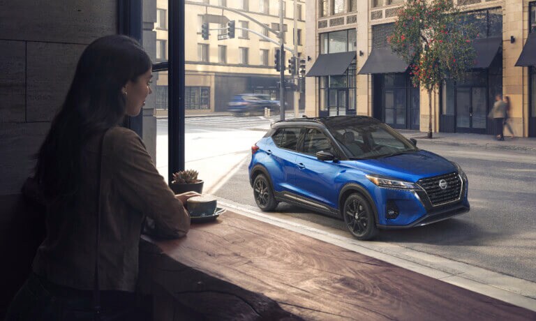 2022 Nissan Kicks with black wheels parked on street outside coffee shop
