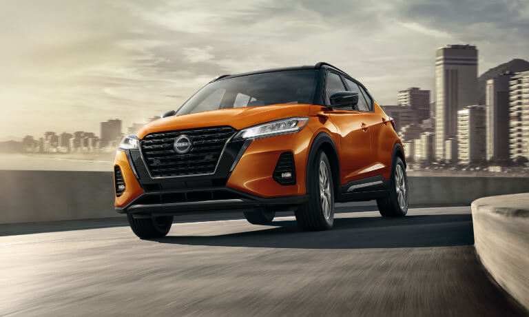 2023 Nissan Kicks driving on a curve out of city