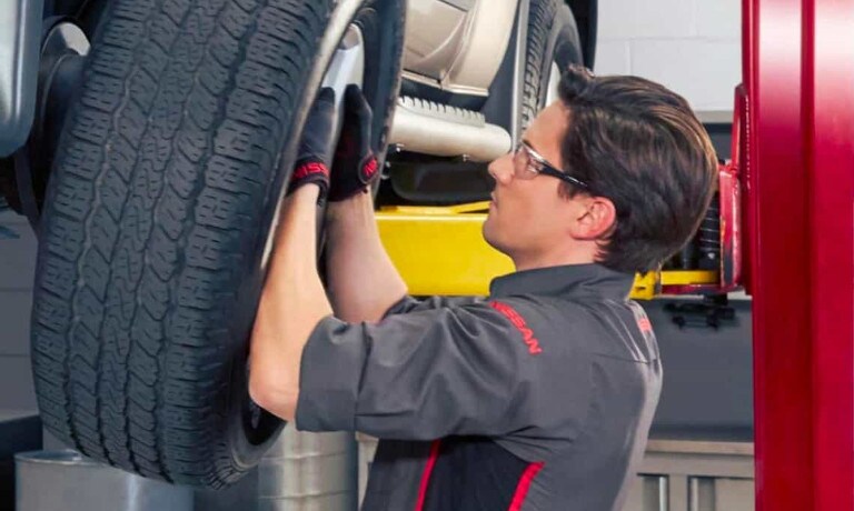 Nissan technician replacing a tire
