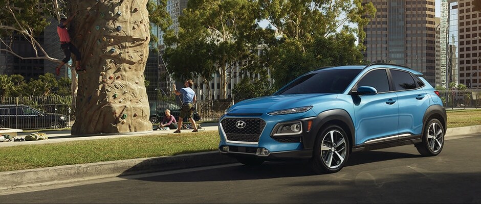 Hyundai Kona Trims A blue Hyundai Kona parked by an outdoor rock wall