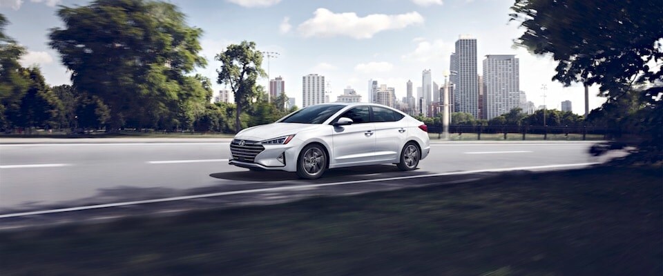 2019 Hyundai Elantra Exterior shot of a white 2019 Hyundai Elantra driving along the road