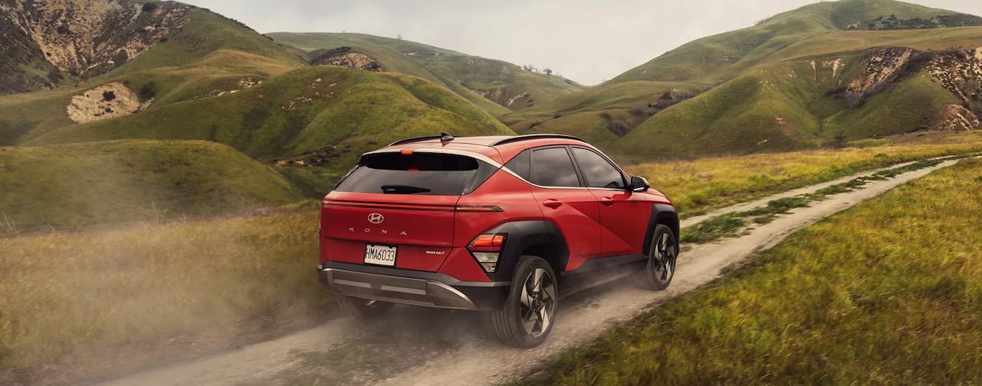 Rear of a red 2025 Hyundai Kona driving down a trail.