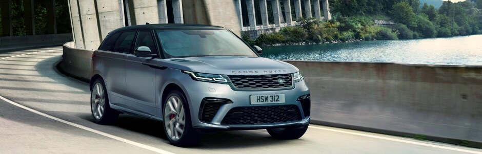 LIGHT BLUE LAND ROVER VELAR DRIVING THROUGH CITY