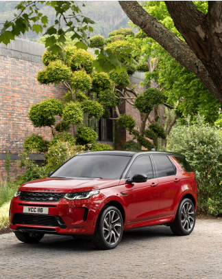 RED LAND ROVER DISCOVERY SPORT PARKED IN CITY