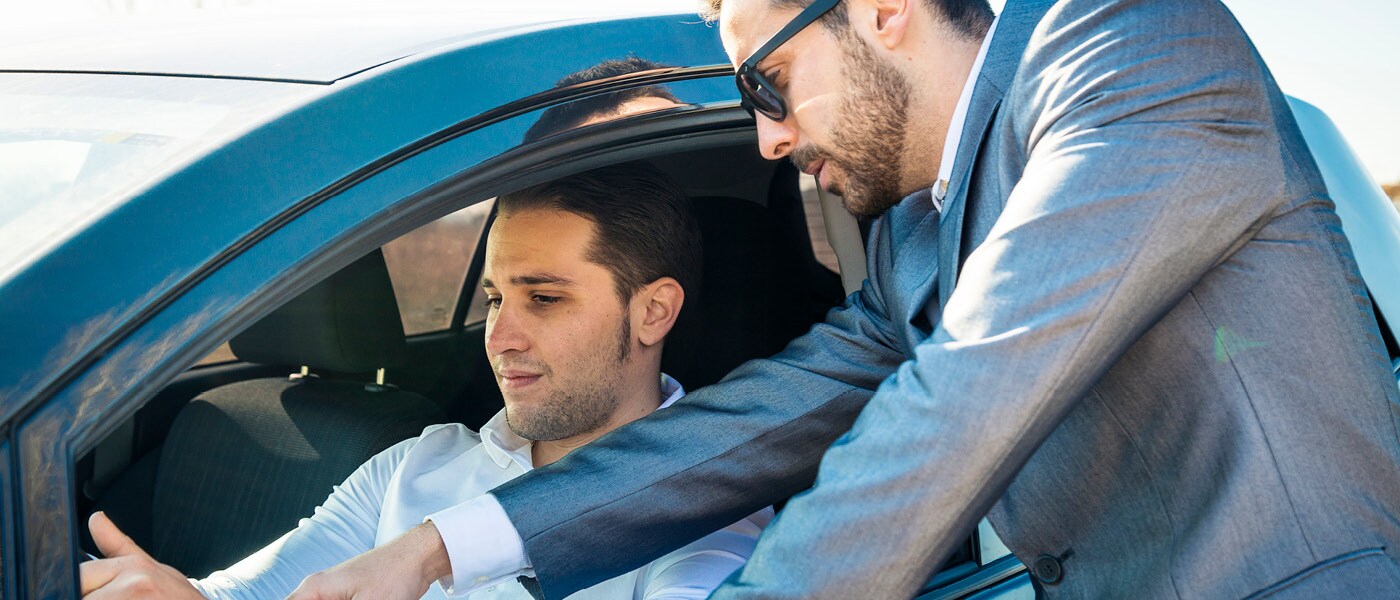 Driver and salesman testing a car