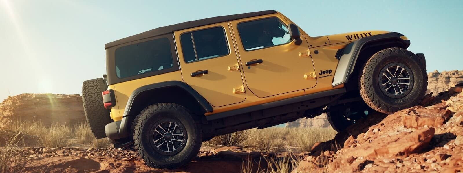 2026 Jeep Wrangler Willys climbing rocky terrain during an off-road adventure
