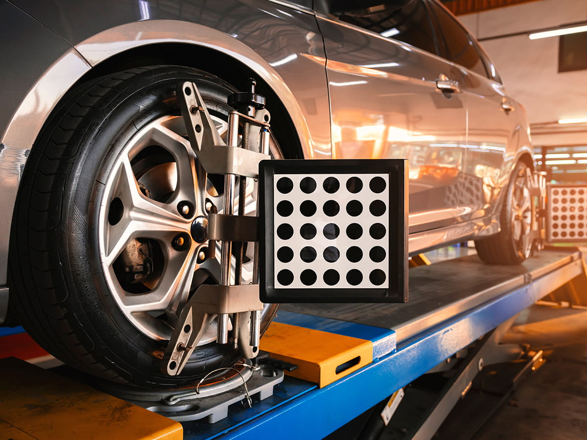 Wheel alignment equipment attached to a vehicle in a service bay