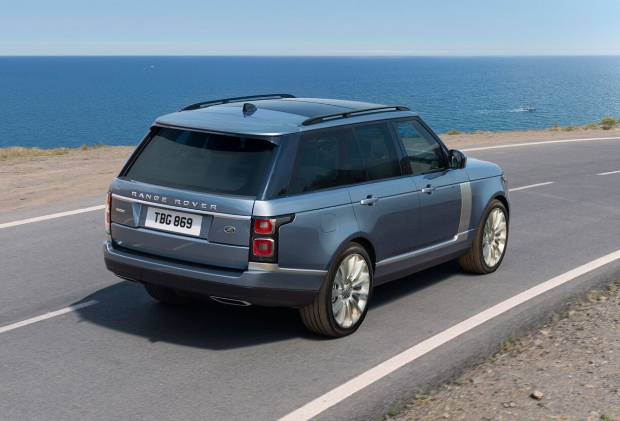 Blue 2020 Range Rover driving on a highway near the pacific ocean