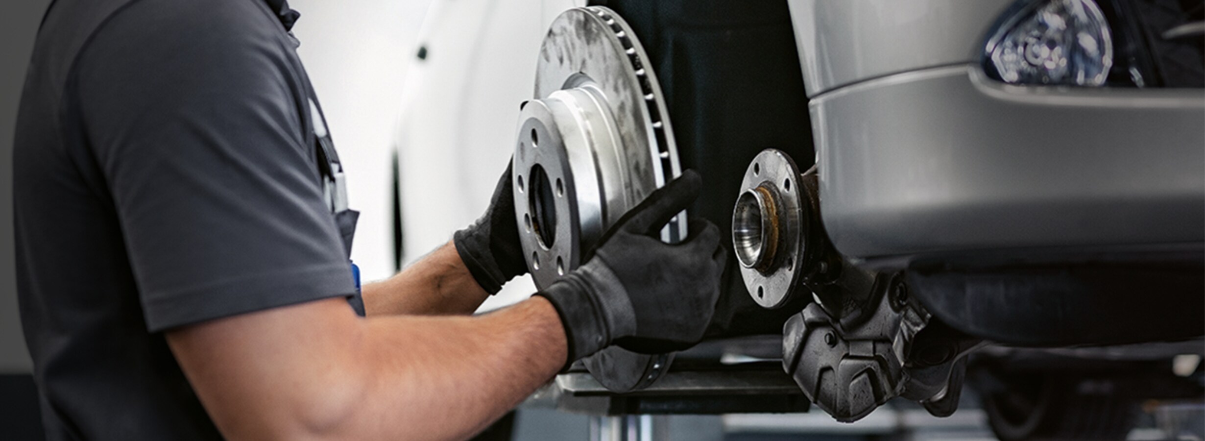 A BMW service technician holding the brake discs of a vehicle A BMW service technician holding the brake discs of a vehicle