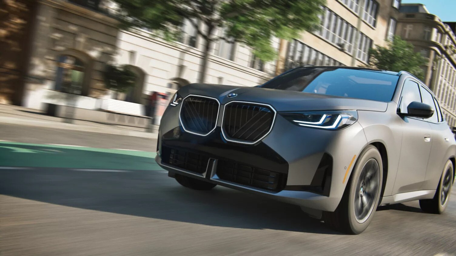 A gray BMW X3 driving down the road in the city. A gray BMW X3 driving down the road in the city.