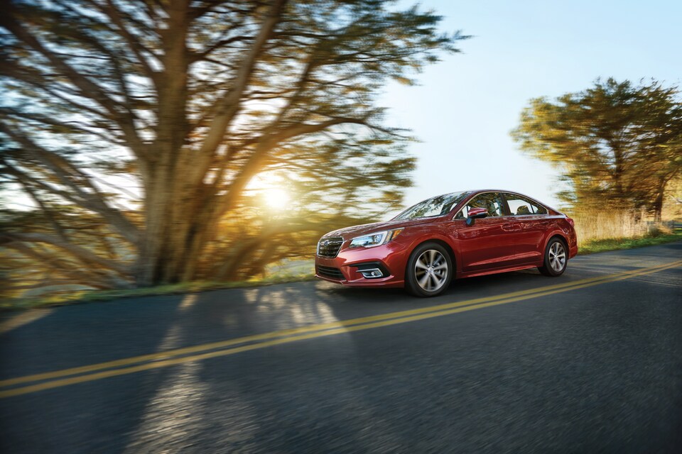 2018 Subaru Legacy 2.5i Limited Sedan red on tree lined road.jpg