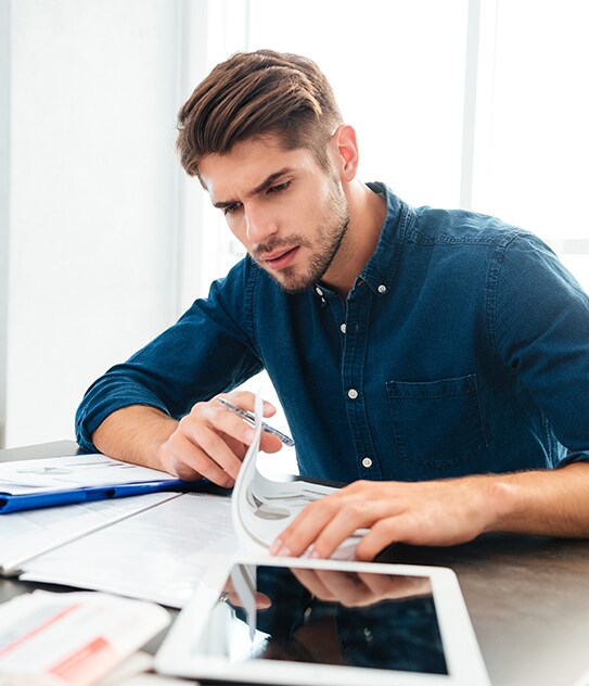 Genesis of York is a Jack Giambalvo Car Dealership in York, PA | Man Sitting at Table Going Over Finances Genesis of York is a Jack Giambalvo Car Dealership in York, PA | Man Sitting at Table Going Over Finances