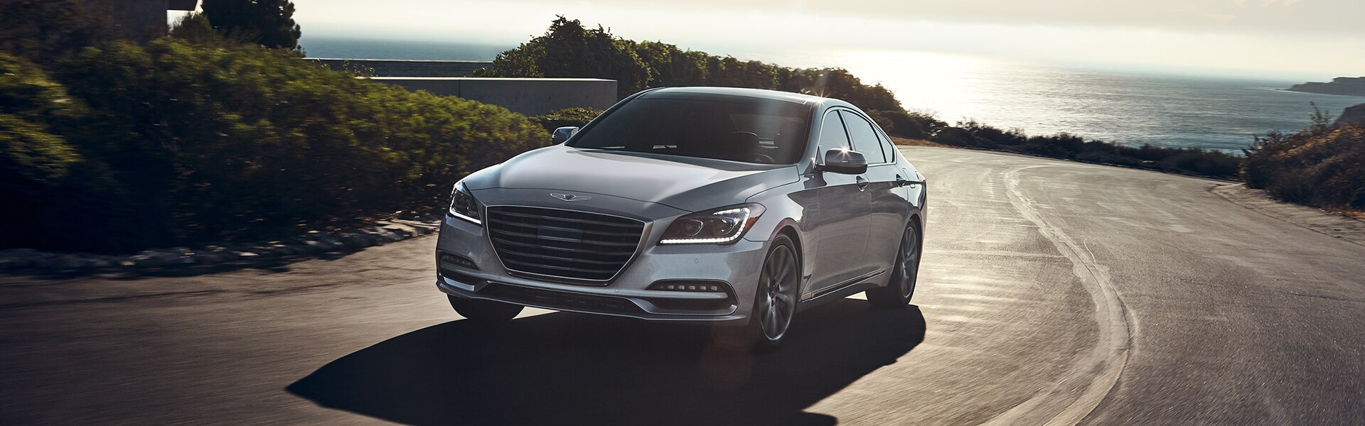 Genesis of York is a Jack Giambalvo Car Dealership in Red Lion, PA | 2020 Genesis G80 driving on road by ocean