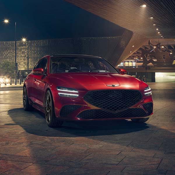Model Features of the 2022 Genesis G70 at Genesis of York | Red 2022 Genesis G70 Parked in City at Night
