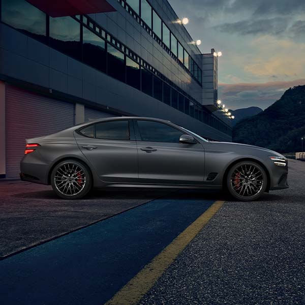 Model Features of the 2022 Genesis G70 at Genesis of York | Dark Silver 2022 Genesis G70 Leaving Parking Garage at Night