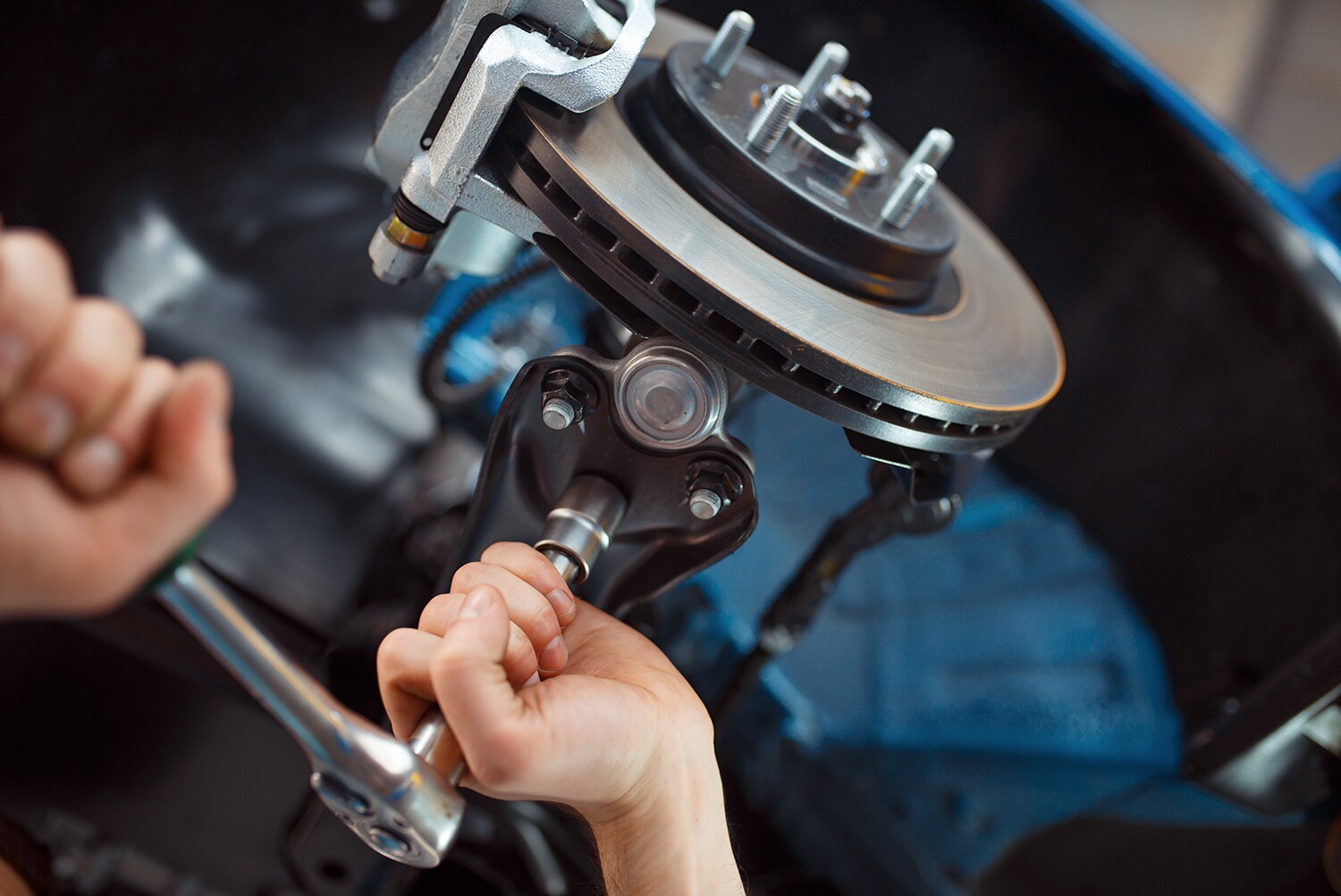 Genesis of York is a Jack Giambalvo Car Dealership in York, PA | Mechanic fixing brakes on a Genesis vehicle
