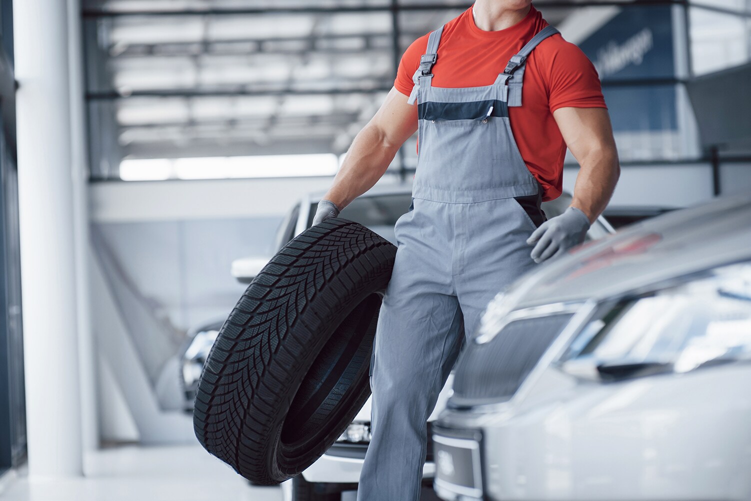 What different tire options are available at Genesis of York in York | Mechanic carrying brand new tire