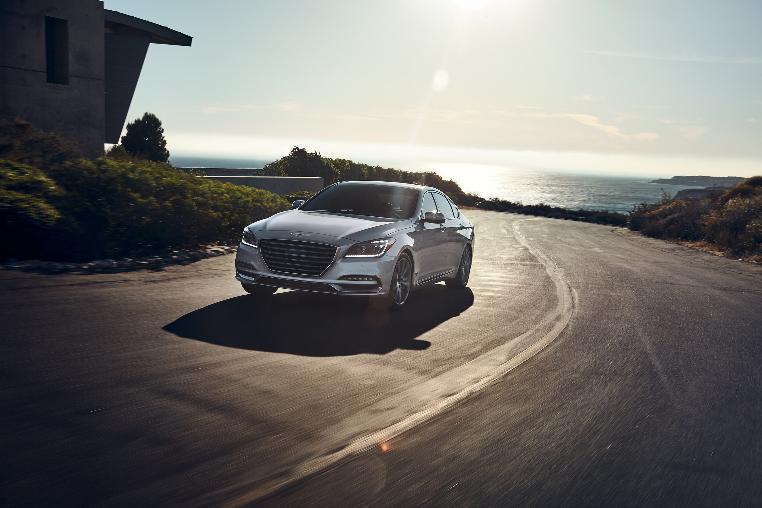 2020 Genesis G80 driving on backroad with view of water | Genesis of York is a Jack Giambalvo Car Dealership near Manchester, PA