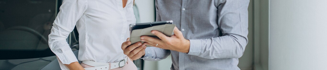 Vehicle Registration Taxes and Fees at Jack Giambalvo Hyundai in York, PA | Man on the right is holding an iPad with information on it and showing it to a customer on the left wearing a white shirt