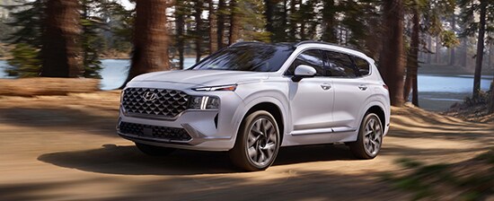 Model Features of the 2022 Hyundai Santa Fe at Jack Giambalvo Hyundai | Santa Fe driving fast in forest