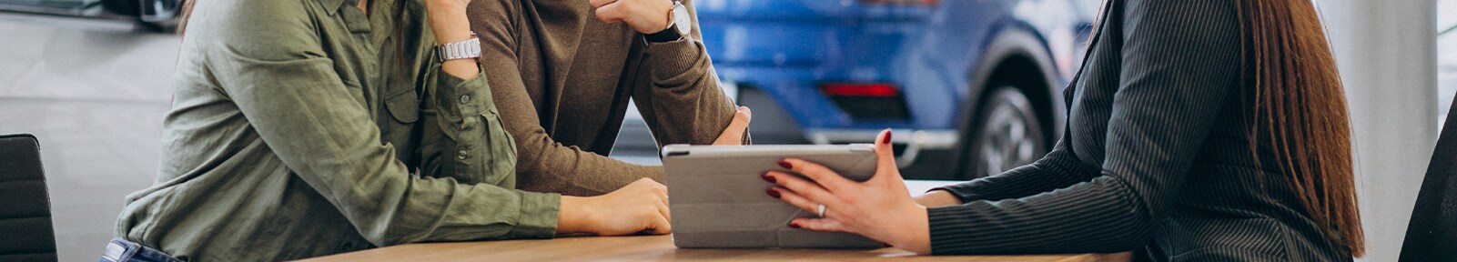 Top Ten FAQs For New Car Buyers in York, PA | Sales person showing ipad of car options to a couple sitting at the table