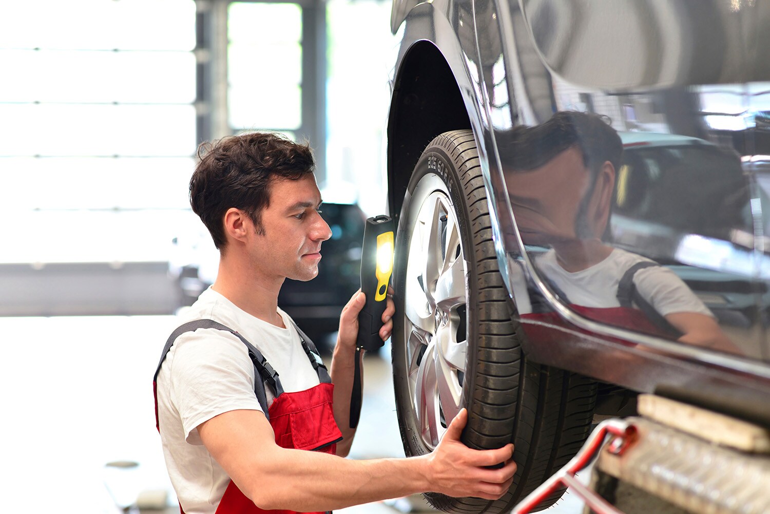 Basic Car Maintenance and Servicing Checklist | Jack Giambalvo Hyundai | Hyundai service technician checking the condition of the tires on a vehicle