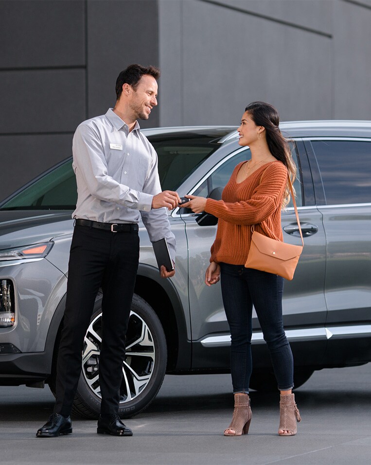 Defining APR at Jack Giambalvo Hyundai in York, PA | Sales person handing over new car keys to customer